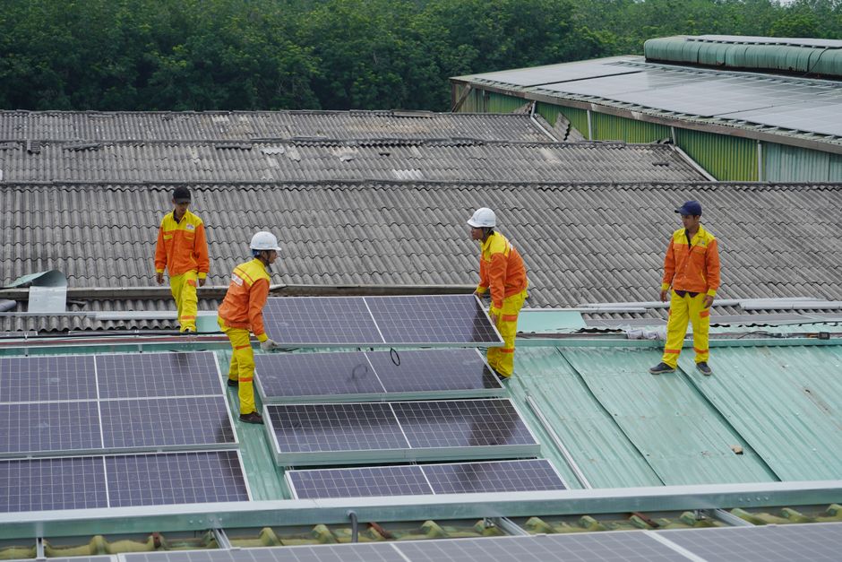 Professional solar panel installers working on a residential roof